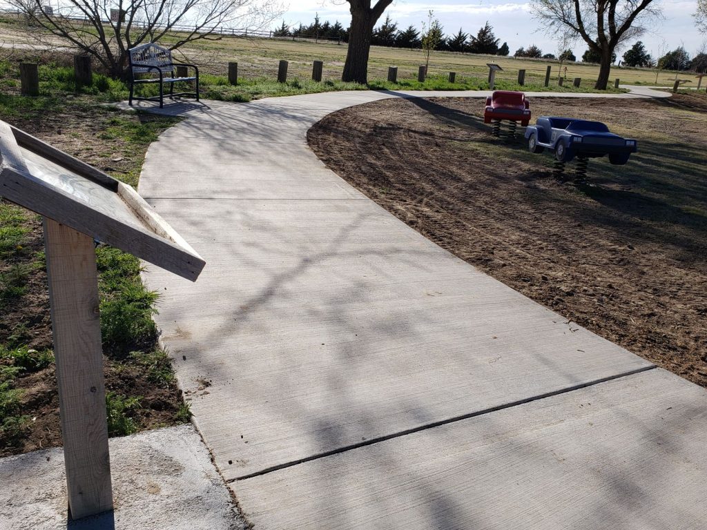 Sidewalk in county park with beginning of Storywalk.